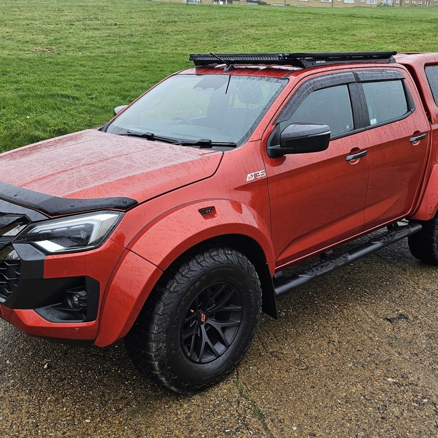 Pick-up roja con canopy, plataforma de techo y estribos