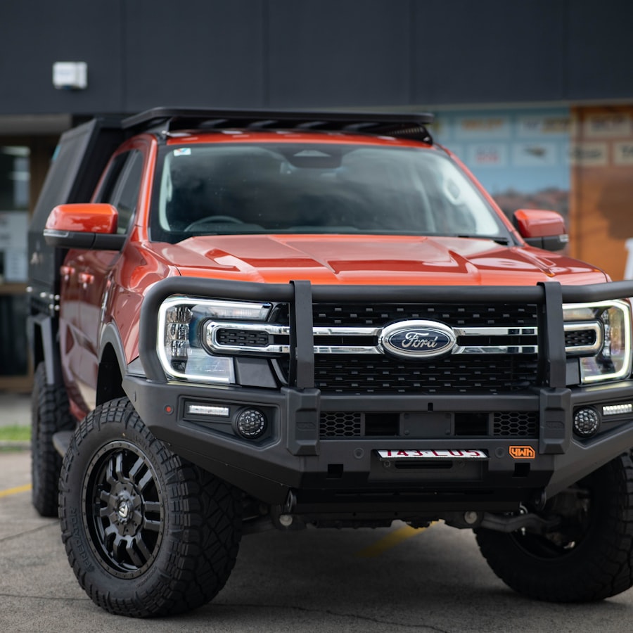 Frente de pick-up naranja con defensa negra y faros LED